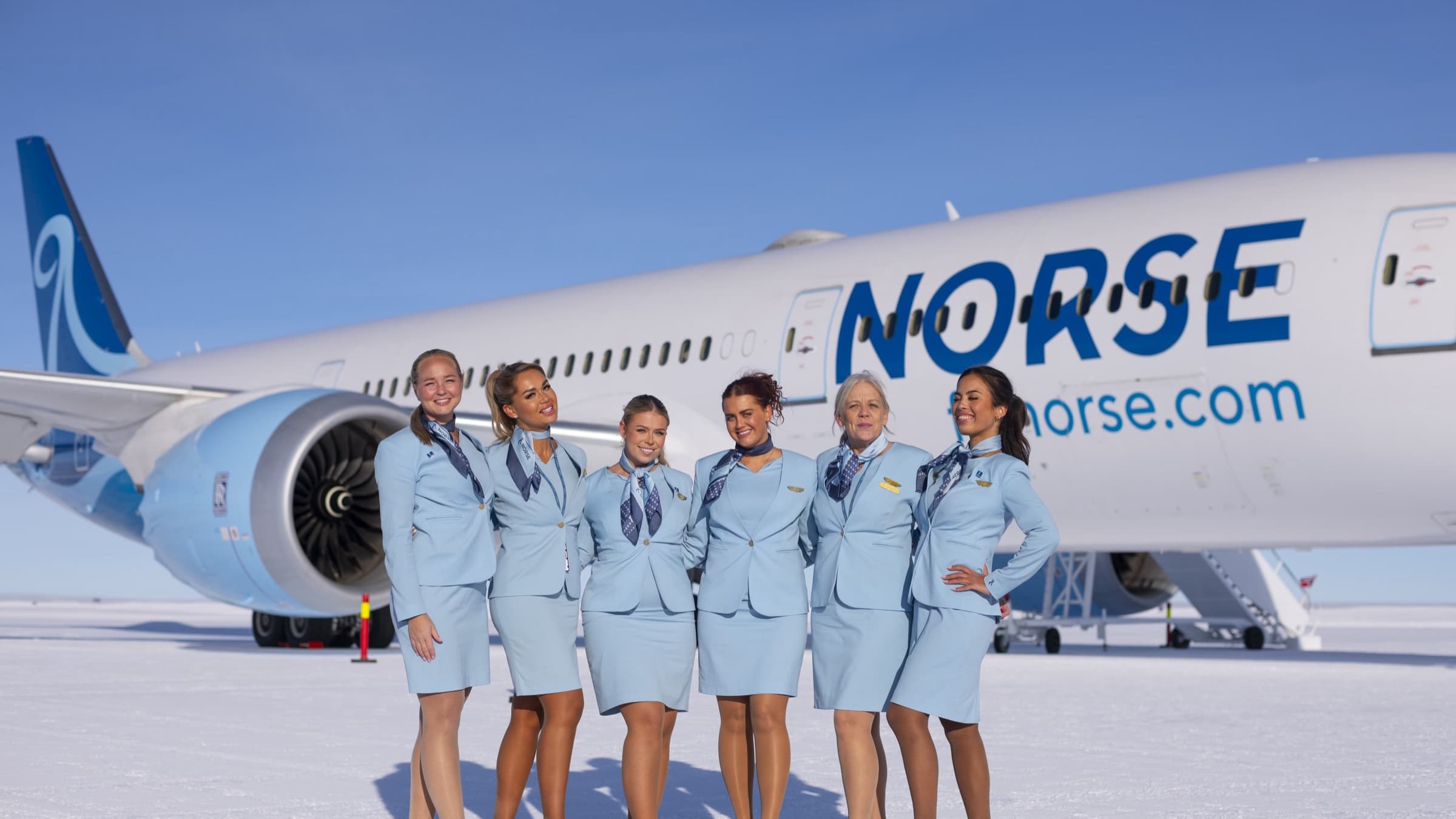ลูกเรือ Norse Atlantic Airways หกคนในชุดยูนิฟอร์มสีฟ้า ยืนหน้าเครื่องบิน Boeing 787 บนพื้นน้ำแข็งแอนตาร์กติกา